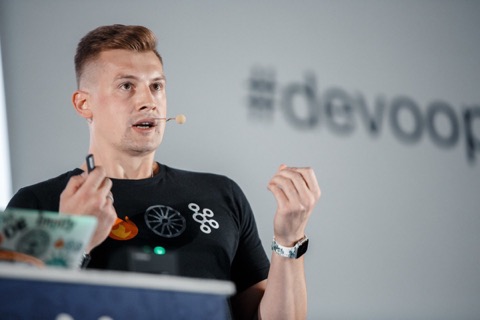Viktor Gamov speaking on stage at Devoops