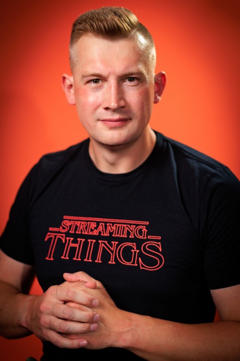 Studio portrait of Viktor Gamov on an orange background